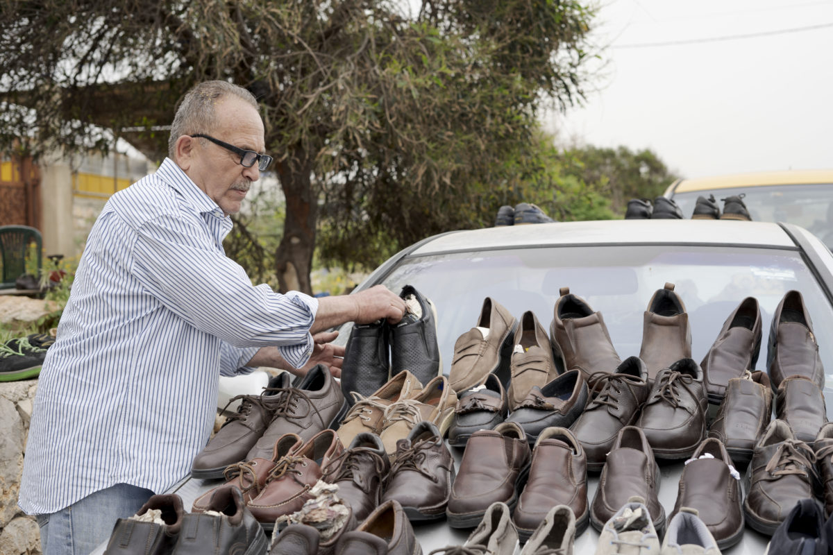 Ismael Abu Melhem sælger sko foran kraftværket i Jiyeh. Han har vejrtrækningsbesvær og har haft lungekræft i seks år. “Vi er mange, der har kræft i det her område” siger Abu Melhem. “Der er ingen, der spørger til os normalt. Vores situation er ussel”. Foto: Florian Elabdi
