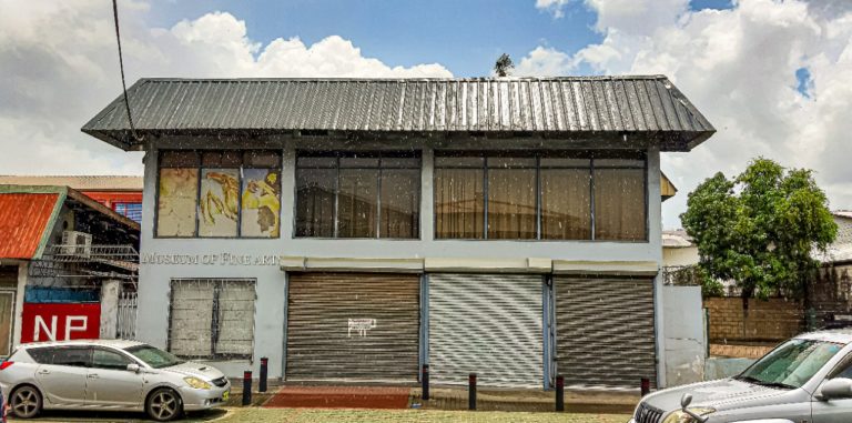 HPSG's hovedkvarter i Paramaribo har adresse i en nedslidt, blå bygning med et skilt, hvor der står "kunstmuseum".