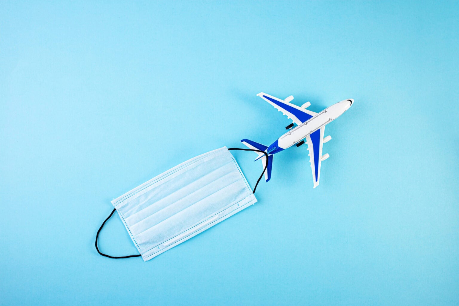 Model airplane with Protective medical mask. personal protective equipment. Self isolation