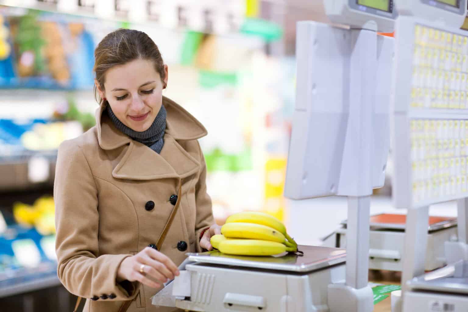 Beautiful young woman shopping for fruits and vegetables in prod