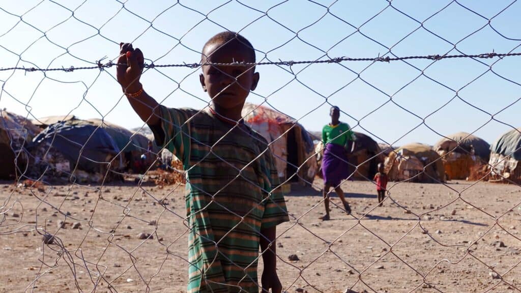 Turkana boy behind the fence around Sarima, protecting the community from wild animals and violent attacks from other tribes.