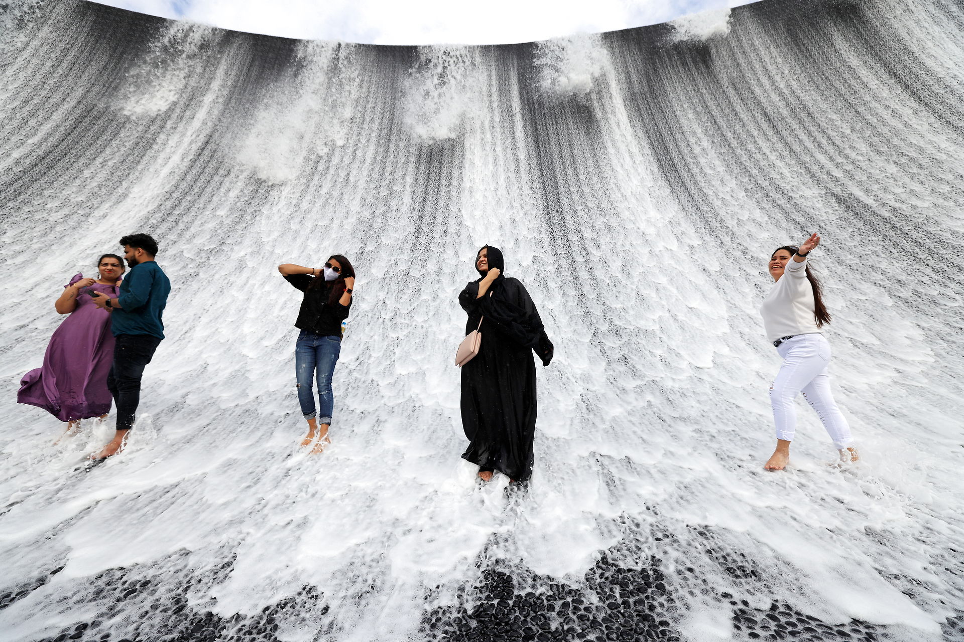 Visitors are pictured at the water feature at Dubai Expo 2020, in Dubai