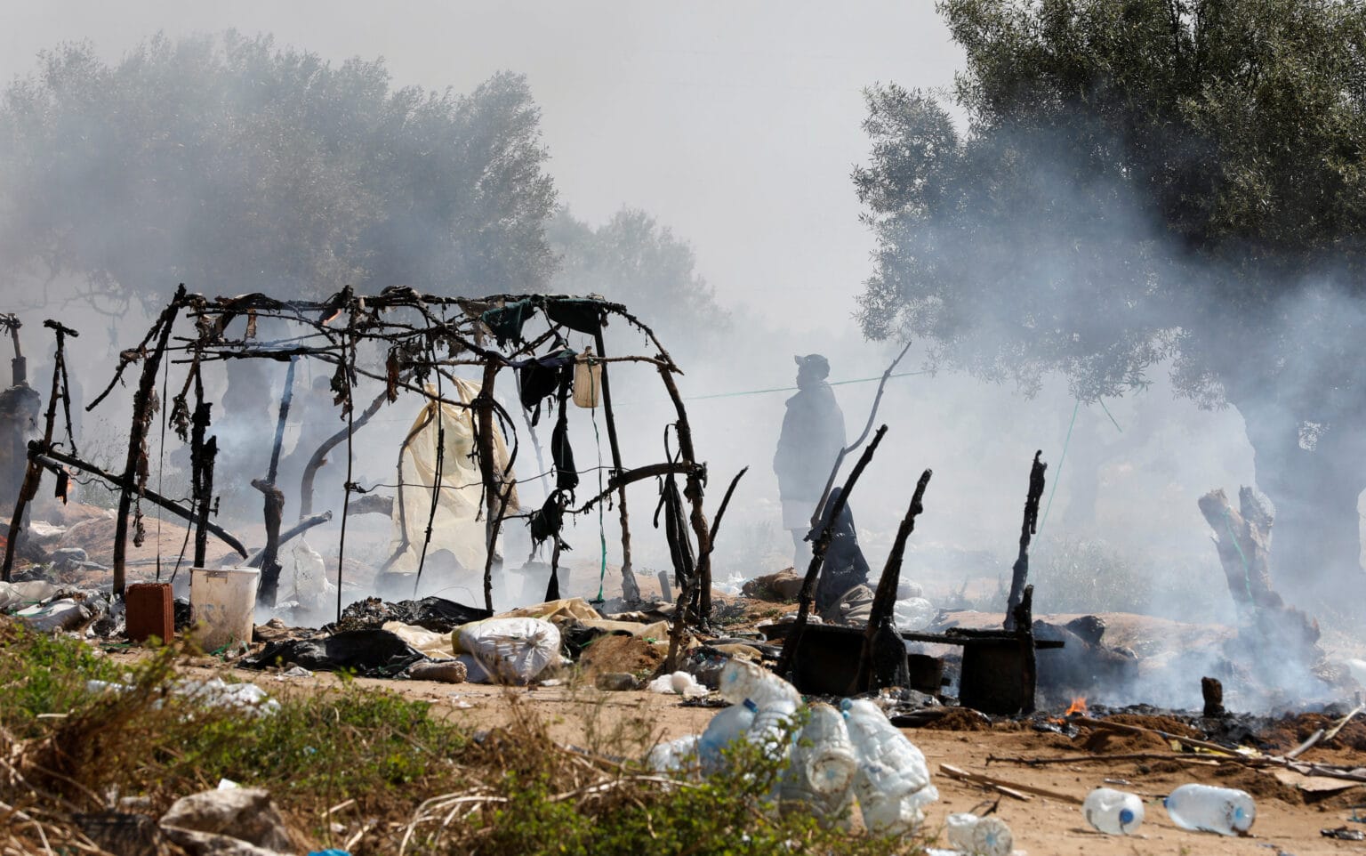 A man stands near burnt tents as tunisian authorities have dismantled makeshift camps housing sub saharan african migrants