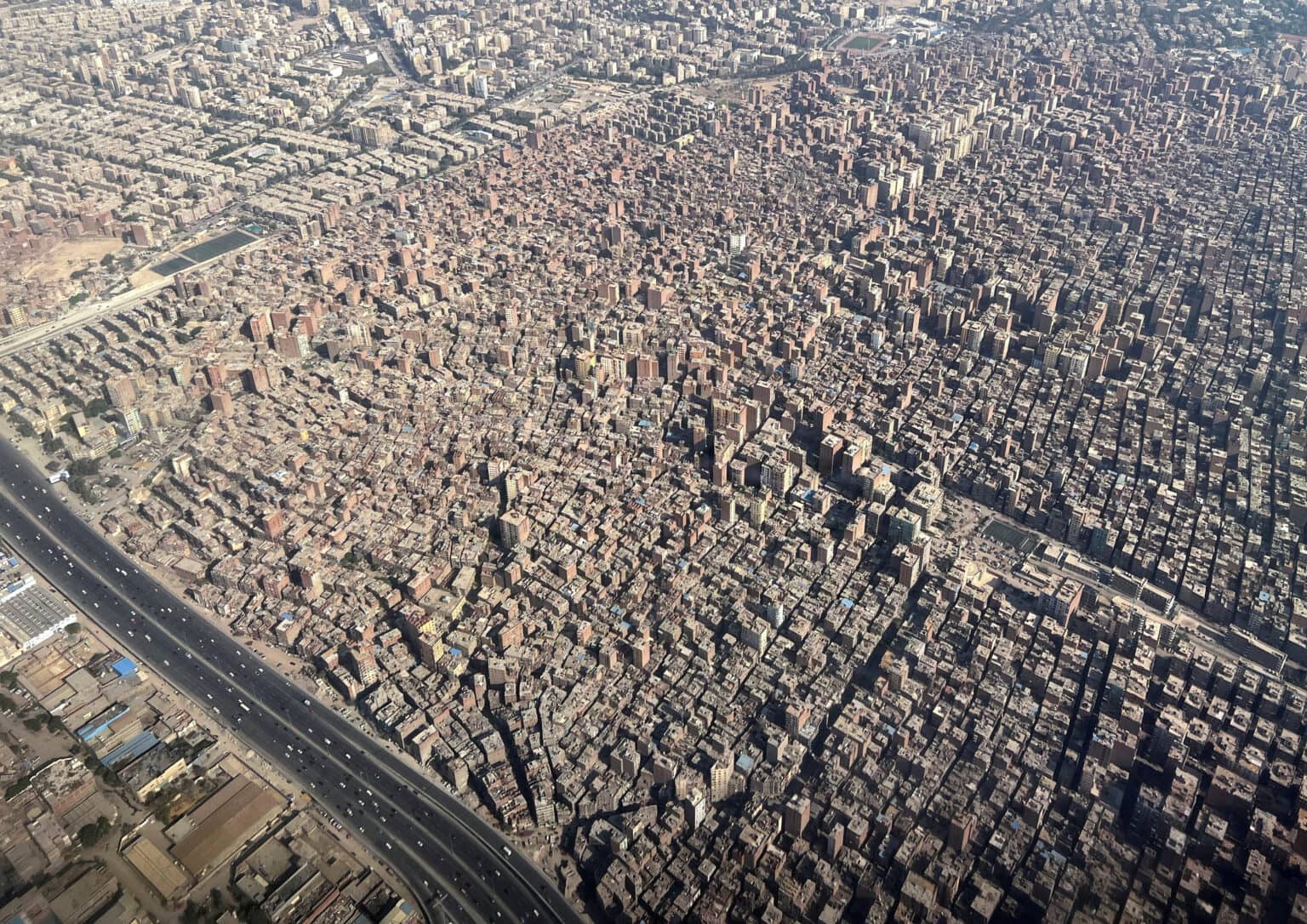A view from an airplane window of buildings in a densely populated area, in Cairo